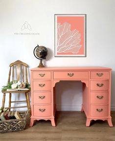 an orange desk with drawers and a clock on it's stand next to a chair