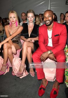 three people sitting next to each other at a fashion show