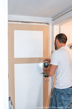 a man is working on the door with a screwdriver and tape measures