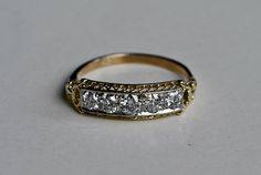 a gold and white diamond ring sitting on top of a table