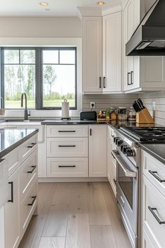 a kitchen with white cabinets and stainless steel appliances