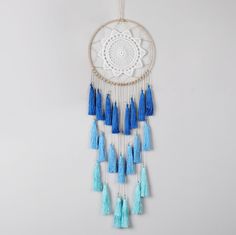 a blue and white dream catcher hanging on a wall