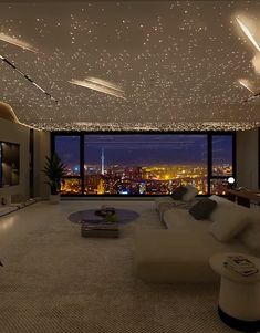 a living room filled with lots of furniture and a large window overlooking the city at night