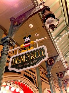 the sign for disney and co is hanging from the ceiling