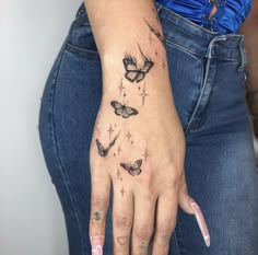 a woman's hand with three butterflies on it