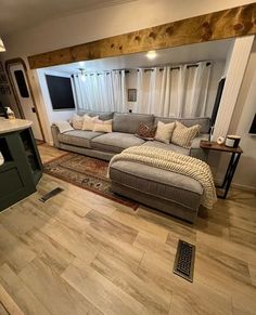 a living room filled with furniture next to a kitchen