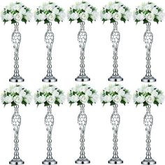 six silver vases with white flowers and greenery in them on a white background