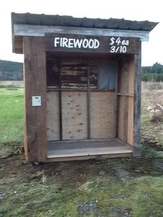 a wooden outhouse sitting on top of a lush green field