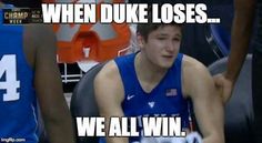 a man sitting on top of a basketball court next to another person wearing a blue uniform