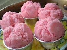 four pink ice creams sitting on top of a yellow and blue plate