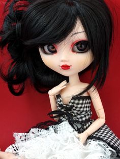 a close up of a doll with black hair and red eyes on a red background