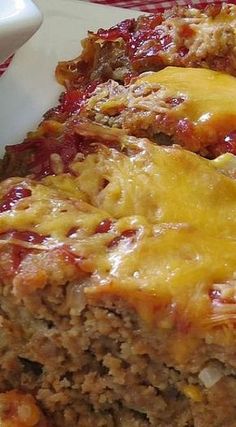 meatloaf with cheese and sauce on a white plate next to a red napkin