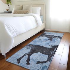 a bed with a blue rug on top of it next to a white headboard