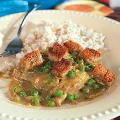 a white plate topped with rice and peas next to a bowl of chicken pot pie