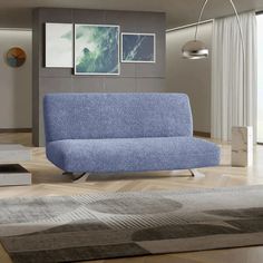 a blue couch sitting on top of a hard wood floor next to a white rug