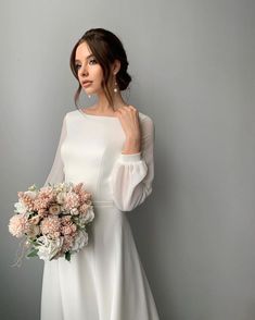 a woman in a white dress holding a bouquet of flowers