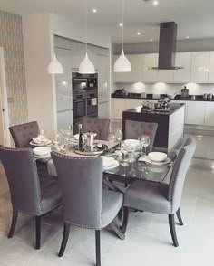 an image of a dining room table and chairs in the middle of a large kitchen