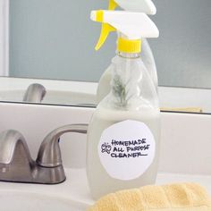 a bottle of homemade cleaner sitting on top of a bathroom sink next to a yellow towel