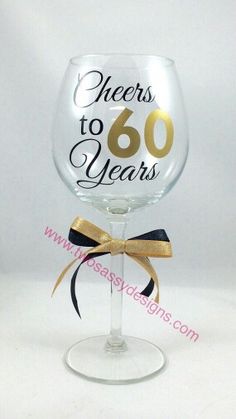 there is a wine glass with the words cheers to 60 years on it and a bow