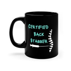 a black coffee mug with the words certified back stabber printed on it's side