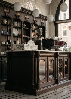 an old fashioned kitchen with marble counter tops and wooden cabinets, along with hanging lights