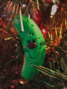 a green ornament hanging from a christmas tree