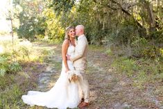 a bride and groom pose for a wedding photo in the woods on their wedding day