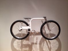 a bike is shown on the wall in front of a white background with shadow from it