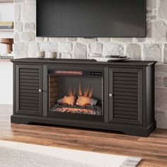 an entertainment center with a flat screen tv mounted above it and a fire in the fireplace