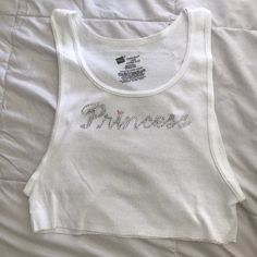 White tank top with "Princess" bedazzled in silver rhinestones! Tank Top Design Ideas, Bedazzled Clothes, Tiny Shirts, Bedazzled Top, Rhinestone Tank Top, Y2k Shirts, Rhinestone Outfit, Rhinestone Shirts, Rhinestone Top