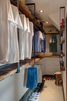 there is a closet with clothes hanging on the wall and shoes in the floor below