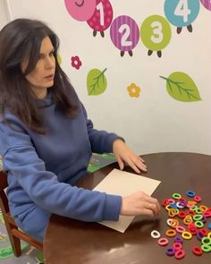 a woman sitting at a table with lots of magnets on it