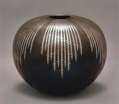 a black vase with white lines on it