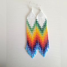 a pair of beaded earrings hanging on a wall