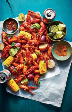 lobsters, corn on the cob, and salsa are served with lime wedges