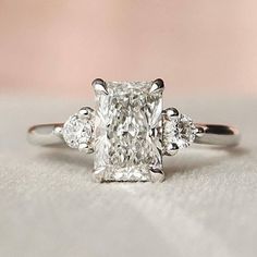 a cushion cut diamond ring with three stones