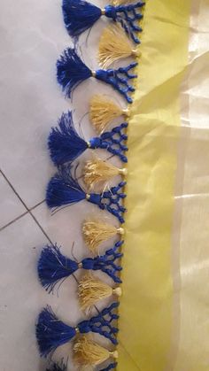 blue and yellow tassels are lined up on the floor