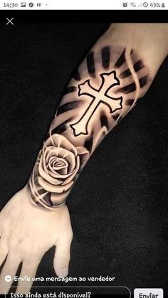 a person with a cross and rose tattoo on their arm, next to a hand