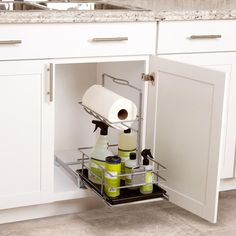 an open cabinet in a kitchen filled with cleaning products