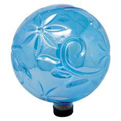 a blue glass ball sitting on top of a black stand with leaves and flowers painted on it