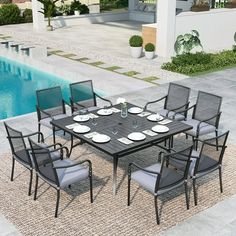 an outdoor dining table and chairs next to a swimming pool