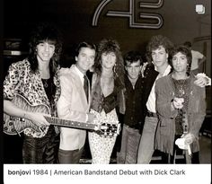 a group of people standing next to each other holding guitars