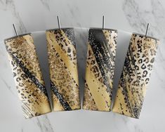 four decorative candles sitting on top of a marble counter