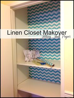 a white shelf with blue and white chevron paper on it, next to a wallpapered closet