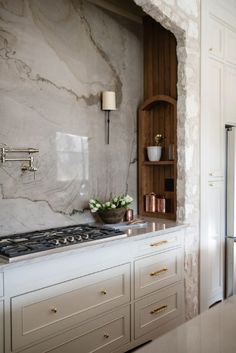 a kitchen with marble counter tops and white cabinets