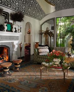 a living room filled with furniture and a fire place in front of a large window