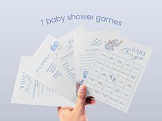 a hand holding four baby shower games