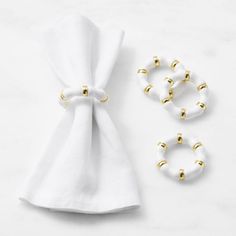 two napkin rings, one with gold studs and the other with white satin material