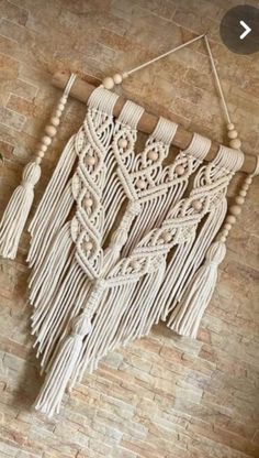 a wall hanging made out of macrame with tassels and wood beads