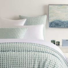 a bed with green and white checkered bedspread, pillows and pillow cases